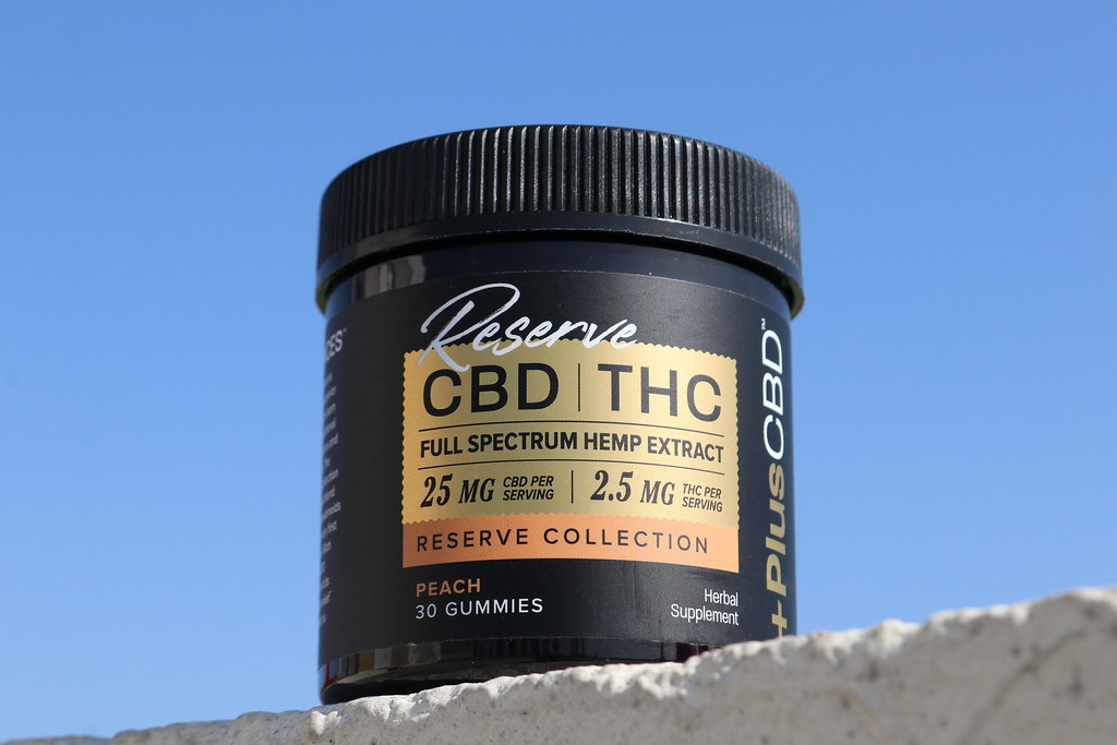 Jar of Reserve CBD THC peach gummies against a clear blue sky